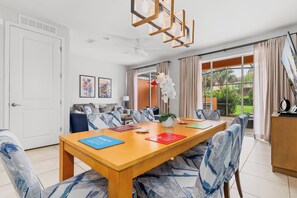 A dining area with a wooden table, chairs, and a ceiling fan.