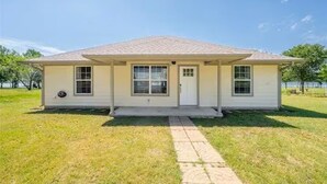 A single-story house with a gabled roof, a front porch, and a front door. - Luxurious, fishing, riding boat and fun at Richland Chambers at Lake front home (Corsicana)