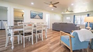 A spacious living area with a dining table and chairs, a sofa, and a ceiling fan. - Luxurious, fishing, riding boat and fun at Richland Chambers at Lake front home (Corsicana)