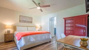 A bedroom with a bed, bedside table, nightstand, and a red dresser. - Luxurious, fishing, riding boat and fun at Richland Chambers at Lake front home (Corsicana)