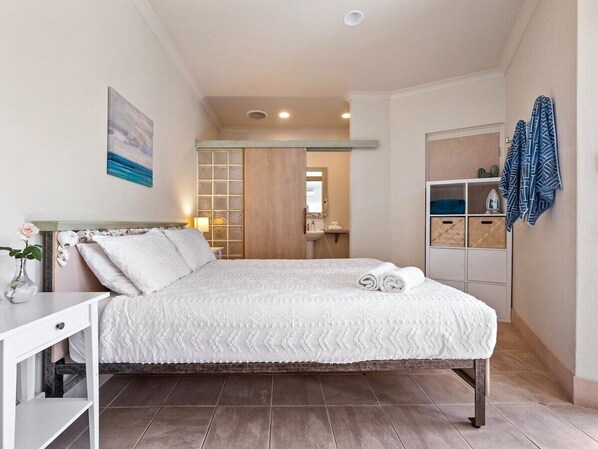 A bedroom with a bed, bedside table, and a wardrobe.