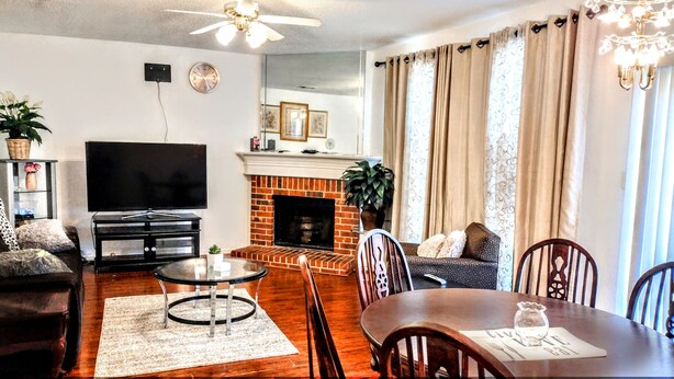 A living room with a fireplace, a TV, and a dining area. - A fully furnished home within walking distance of downtown Mansfield (Mansfield)