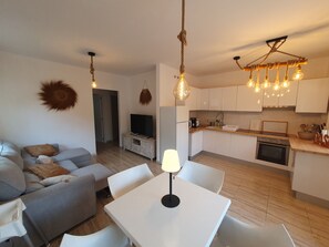 Relax in a cozy living area with a sofa and dining table, complemented by a stylish pendant light.