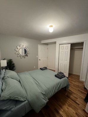 Un dormitorio con una cama, un espejo y dos puertas que dan a otras habitaciones.