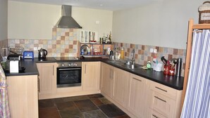 A compact kitchen with a built-in oven, a stainless steel sink, and a tiled backsplash. - 3rd floor, balcony, fireplace or stove, tv, 110m², Pralognan-la-Vanoise (Pralognan-la-Vanoise)