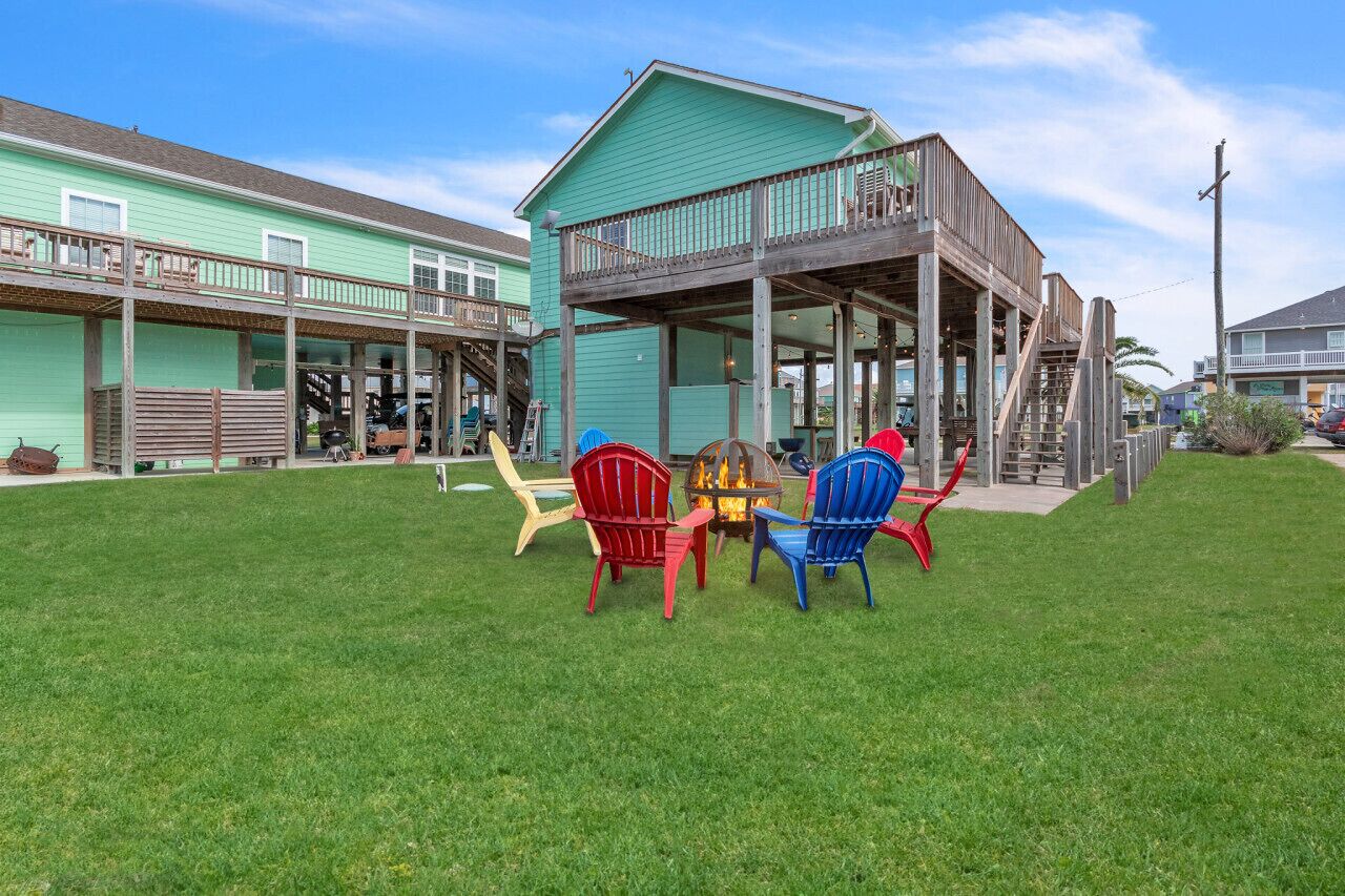 A building with a covered porch and outdoor seating area with chairs.