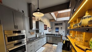 A modern kitchen with stainless steel appliances, wooden flooring, and a mezzanine level. - “The Roost” downtown Red Lodge, MT (Red Lodge)
