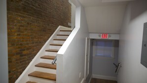 A staircase with wooden steps and a brick wall on one side. - II New apartment with Luxury amenities in Boston (Boston)