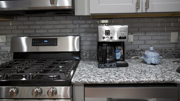 A kitchen with a gas stove, a coffee maker, and a microwave. - II New apartment with Luxury amenities in Boston (Boston)