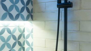 A shower with a handheld head, a flexible hose, and a wall-mounted control.