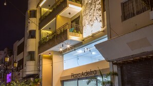 A multi-story building with balconies, a large decorative wall, and a closed storefront with a sign. - Casa Adefra Boutique Hotel Zona Colonial (Santo Domingo)