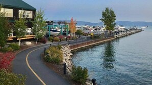 Une propriété située au bord de l’eau, dotée d’une promenade pavée, d’un quai et de bateaux.