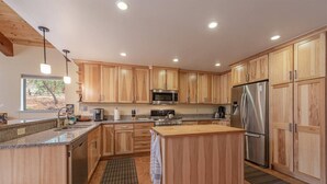 Une cuisine moderne avec des meubles en bois, des appareils en acier inoxydable et un îlot central.