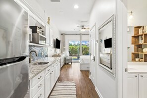 A kitchen with white cabinets, a granite countertop, and a built-in oven.