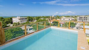 Une piscine sur le toit offrant une vue dégagée sur les bâtiments environnants et la végétation.