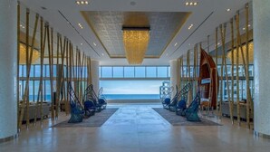 A spacious lobby with a view of the ocean, a large chandelier, and a modern staircase. - Garza Blanca Three Bedroom Loft Los Cabos (Cabo San Lucas)