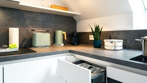 Et moderne køkken med en granitbordplade, indbyggede apparater og en plante.