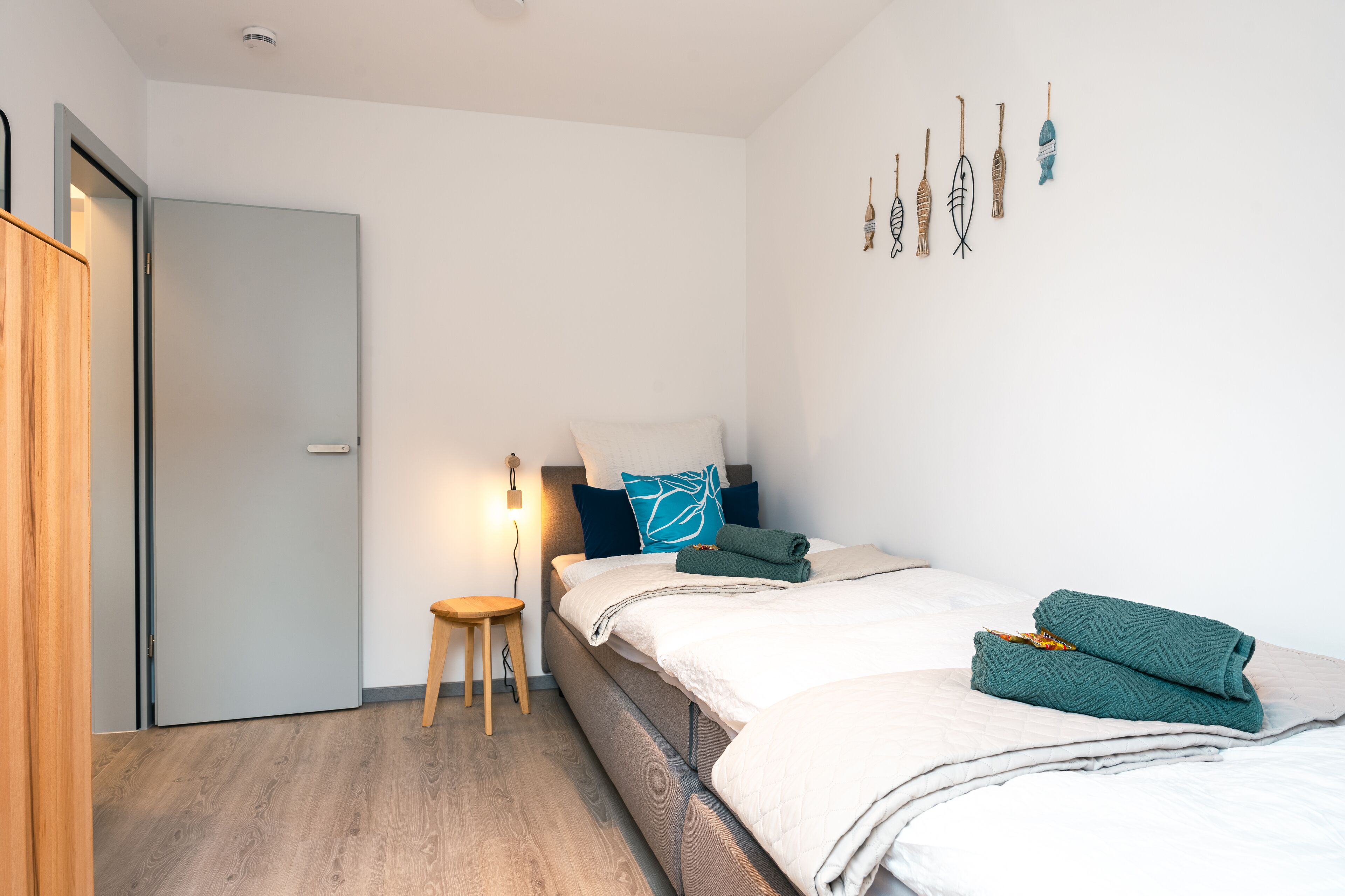 Une chambre moderne avec un lit, une table de chevet et un luminaire fixé au mur.