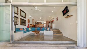 A spacious living area with a curved sofa, a coffee table, and a staircase leading to an upper level. - 4 BR Oceanfront Villa with Pool (Isla Mujeres)