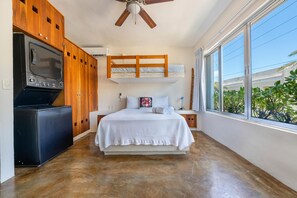 Relax in a compact room with a bunk bed and single bed, both positioned near a window offering a view of lush greenery.