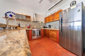 Enjoy cooking in this well-equipped kitchen with a refrigerator, oven, and microwave.