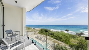 Un balcon avec vue sur l’océan et la plage.