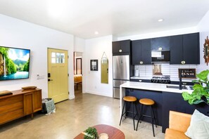 Una cocina moderna con una isla integrada, electrodomésticos de acero inoxidable y una zona de bar.