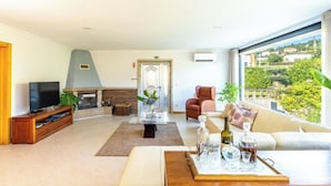 A spacious living room with a fireplace, a television, and a sofa.
