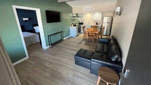 A modern apartment with a living room, dining area, kitchenette, and a bedroom. - Valley Inn and Suites (French Lick)