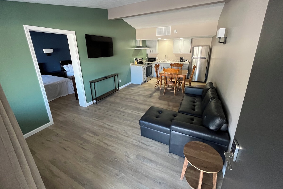 Eine moderne Wohnung mit Wohnzimmer, Essbereich, Küchenzeile und Schlafzimmer.