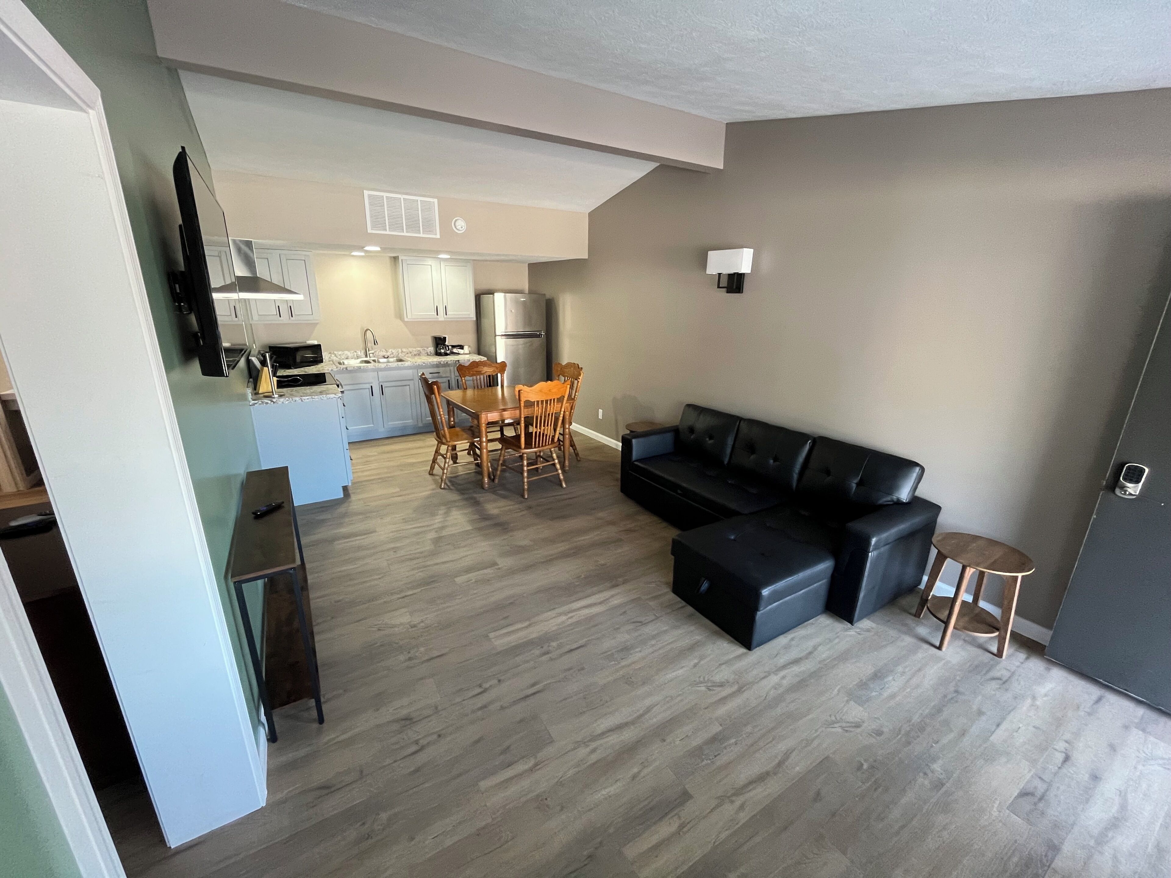 Un apartament modern amb zona de menjador, cuina i saló.