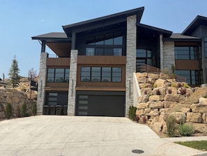 A modern two-story house with a stone facade, large windows, and a garage. - Luxury Home- Minutes from Park City- Family Friendly, Views, Sleeps 16, Spa (Heber City)