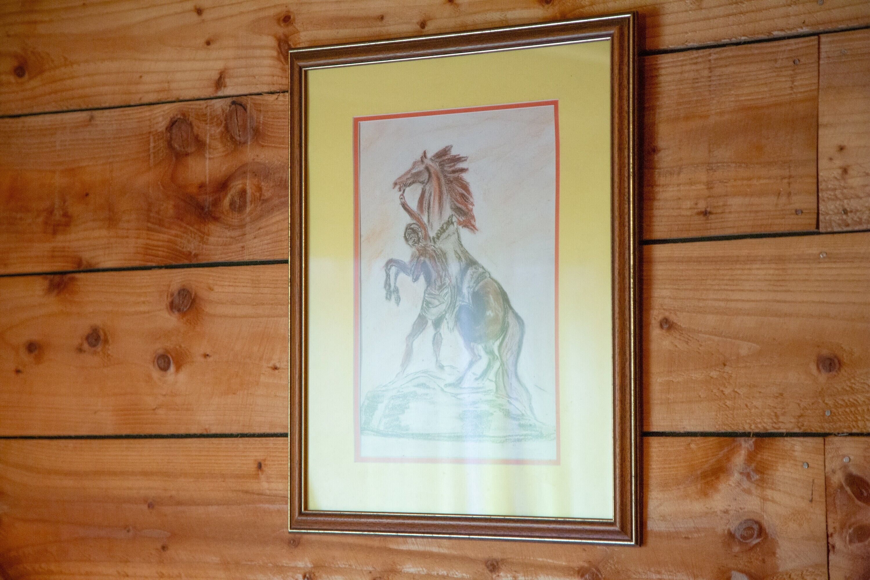 Ein gerahmtes Kunstwerk an einer Holzwand.