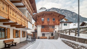 Un bâtiment en bois doté d’un balcon, d’un banc et d’un escalier menant à un deuxième étage.