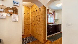 Un intérieur en bois comprenant un coin cuisine, un calendrier mural et un tapis.