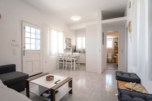 Un salon moderne comprenant un canapé, une table basse et un coin repas avec des chaises et une table.