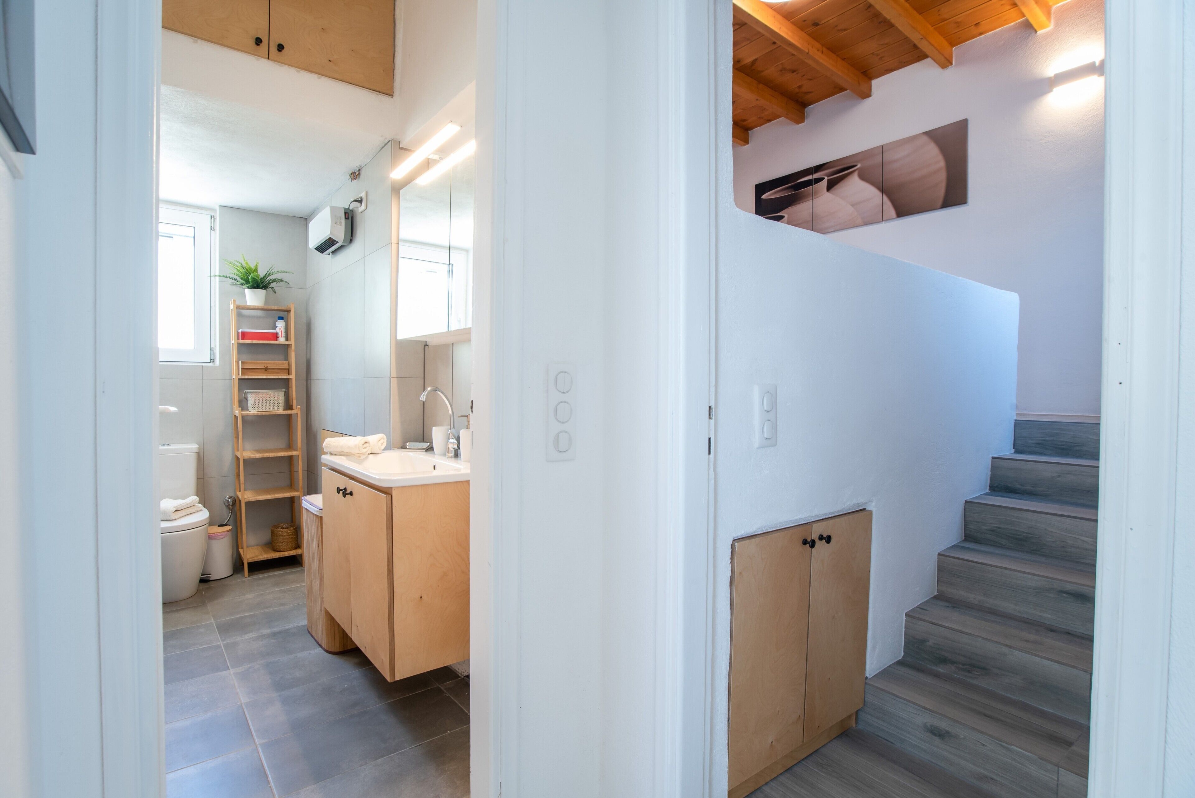Ein modernes Badezimmer mit Toilette, Waschbecken und Holzausstattung.