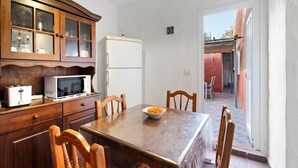 A kitchen with wooden cabinets, a microwave, a refrigerator, and a dining table with chairs. - Apartment 'Trebol 3' with Sea View, Private Terrace and Wi-Fi (El Mocanal)