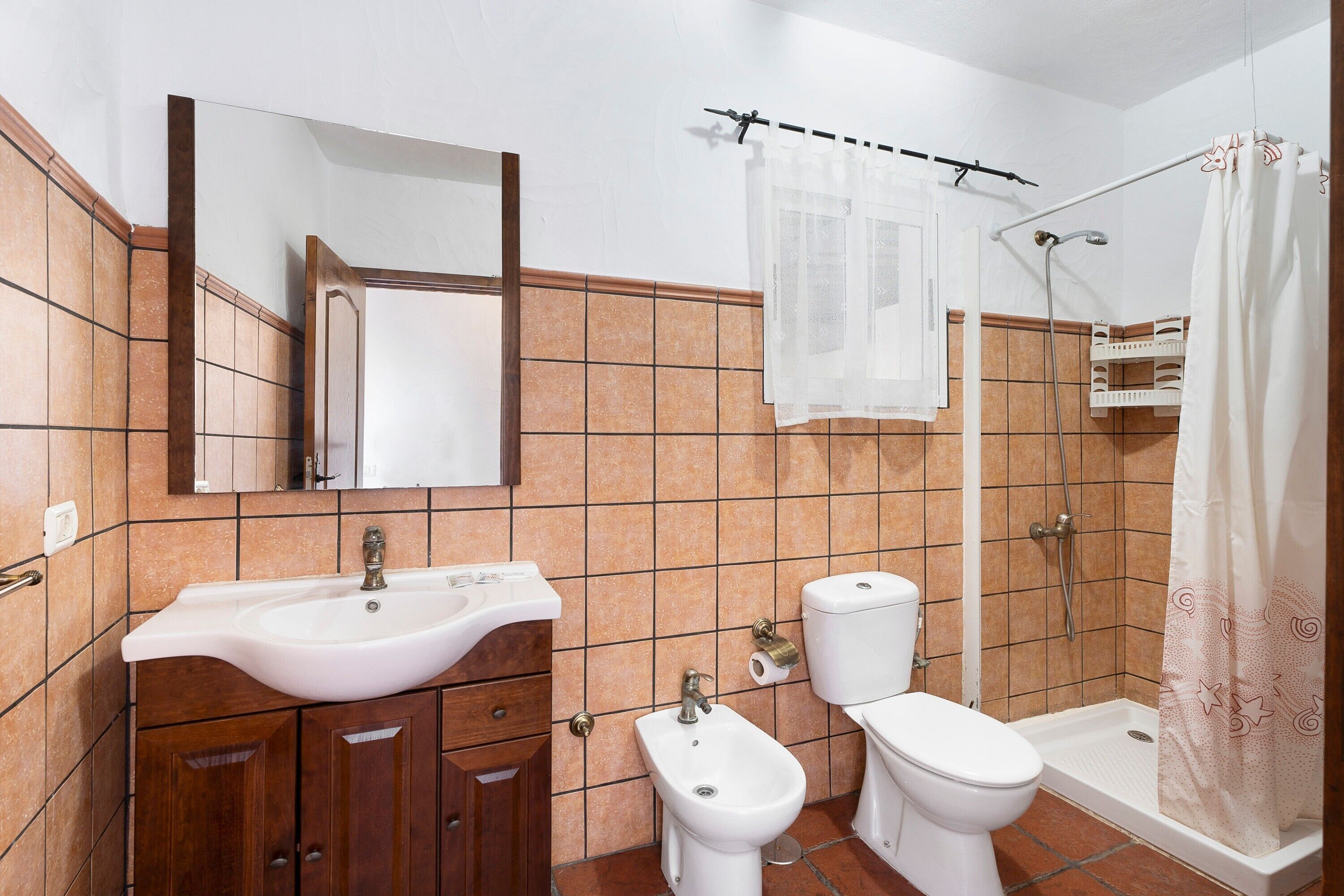 Une salle de bain équipée d’un lavabo, de toilettes, d’un bidet et d’une douche.