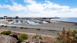 Un port de plaisance avec des bateaux, une route et un ciel dégagé.