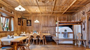 A wooden interior with a dining table, chairs, a bench, and a bunk bed. - Studio Apartment 'Zunerhof  Fenn' with Mountain View, Shared Garden and Wi-Fi (Longostagno)