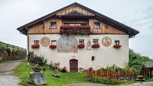 A traditional wooden building with a balcony, a mural, and flower boxes. - Studio Apartment 'Zunerhof  Fenn' with Mountain View, Shared Garden and Wi-Fi (Longostagno)