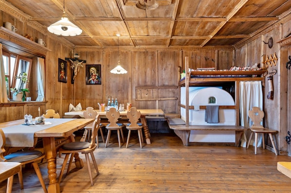 Un interior de madera con una mesa de comedor, sillas, un banco y una cama doble.