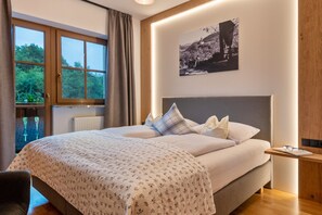 Een slaapkamer met een bed, een raam, een radiator en een aan de muur hangend schilderij.