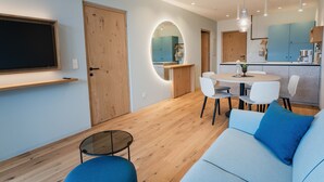 Una sala de estar moderna con un sofá, una mesa de centro y un comedor con sillas y una mesa.