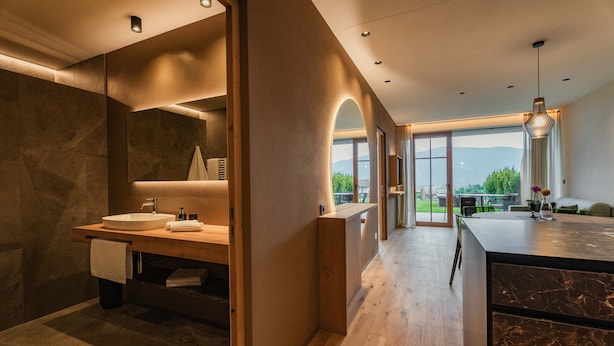Une salle de bain moderne avec un grand lavabo, un miroir et une vue sur l’extérieur.