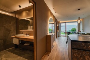 A modern bathroom with a large sink, a mirror, and a view of the outdoors.