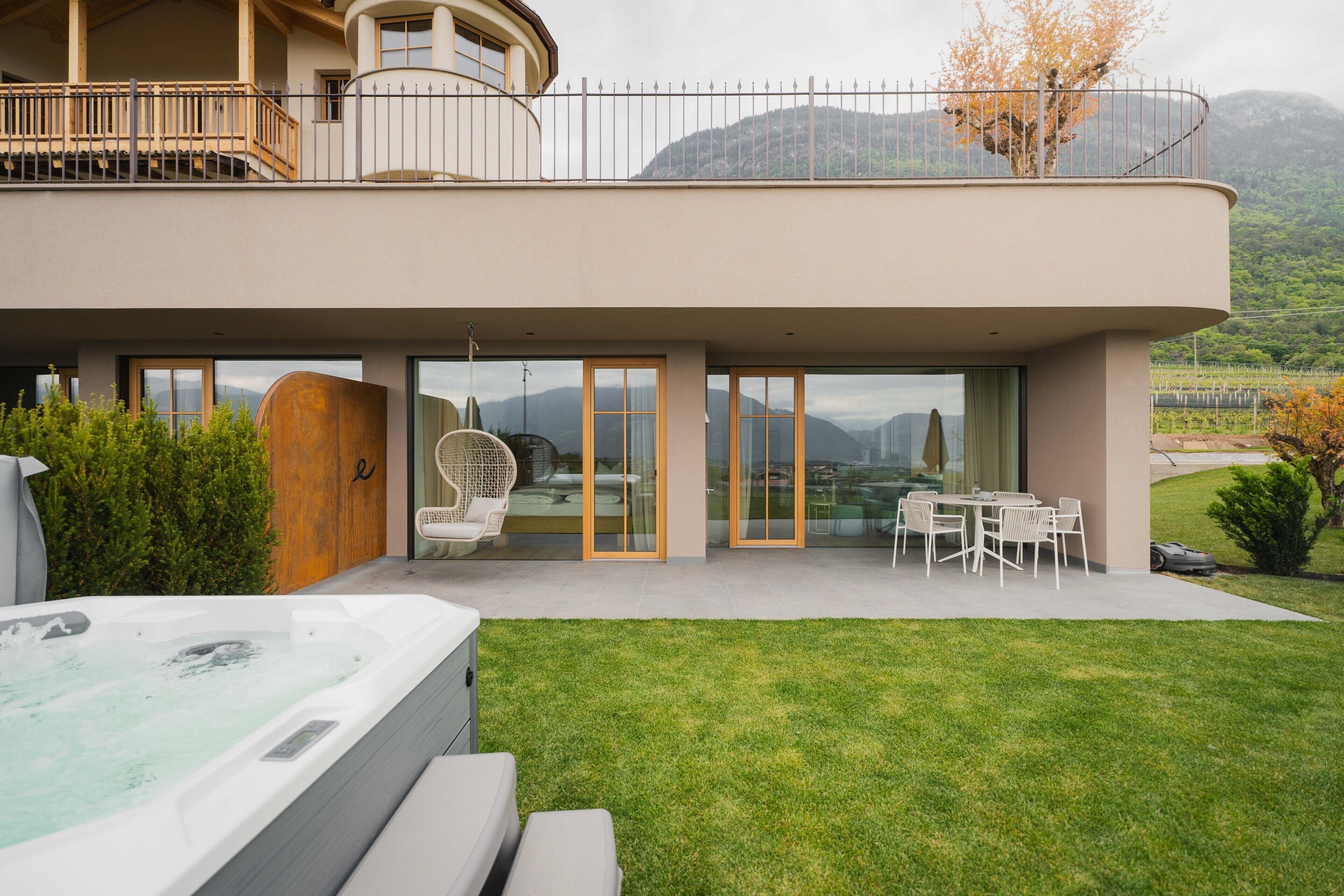 Un bâtiment moderne doté d’un jacuzzi, d’un espace extérieur aménagé et offrant une vue sur les montagnes.