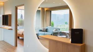 Uma sala de estar moderna com um sofá, uma mesa de madeira e uma TV fixada na parede.