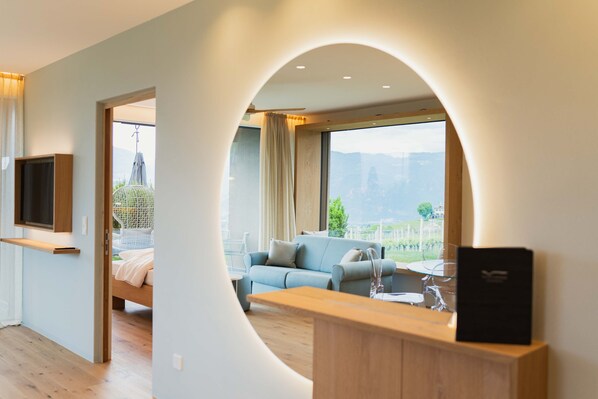 Una sala de estar moderna con un sofá, una mesa de madera y un televisor montado en la pared.